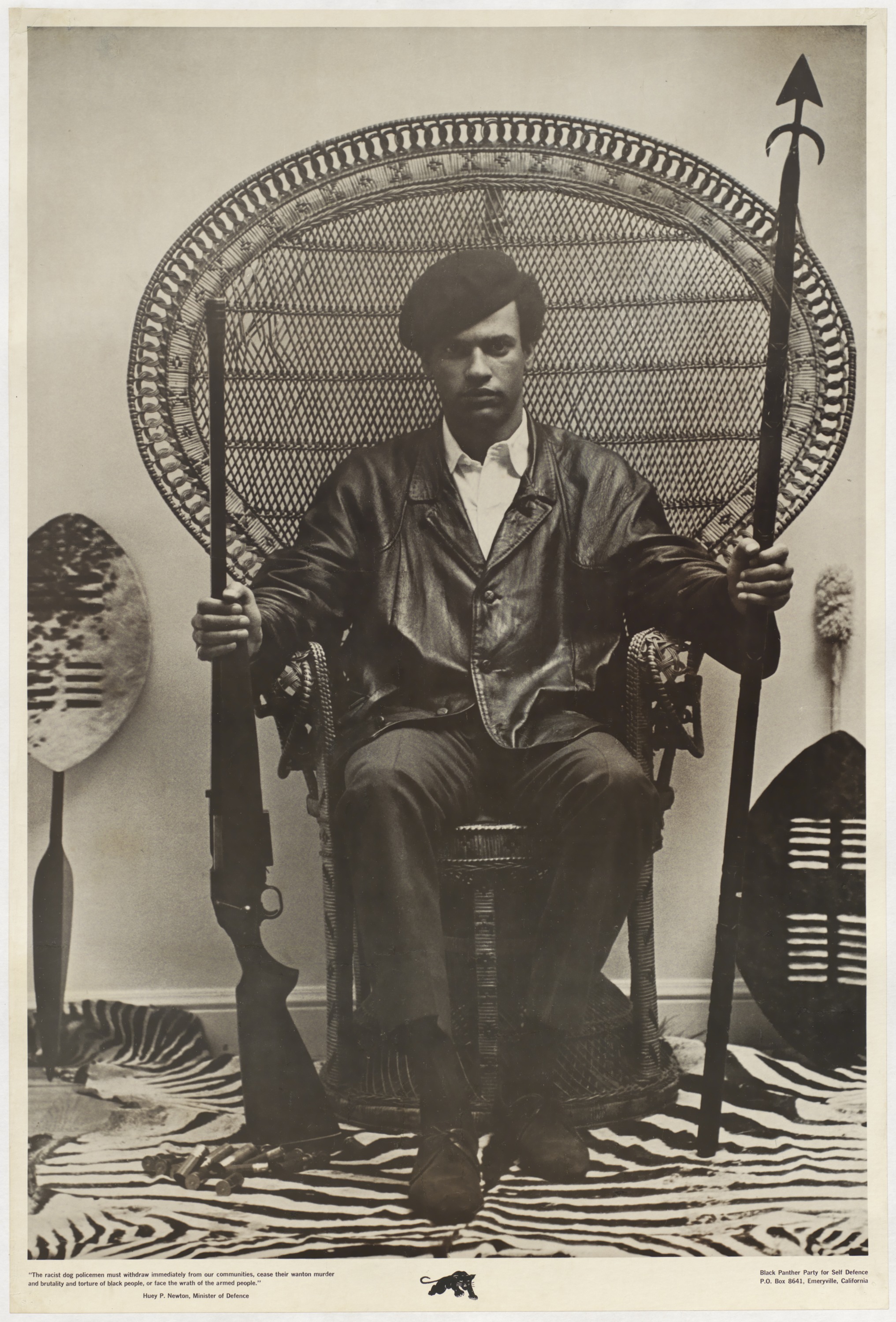 Huey P. Newton seated in a wicker peacock chair, holding a rifle in his right hand and an African spear in his left, flanked by Zulu shields. A zebra-skin rug is beneath. Black Panther Party for Self-Defense poster, 1967. Composition by Eldridge Cleaver, photograph by Blair Stapp.