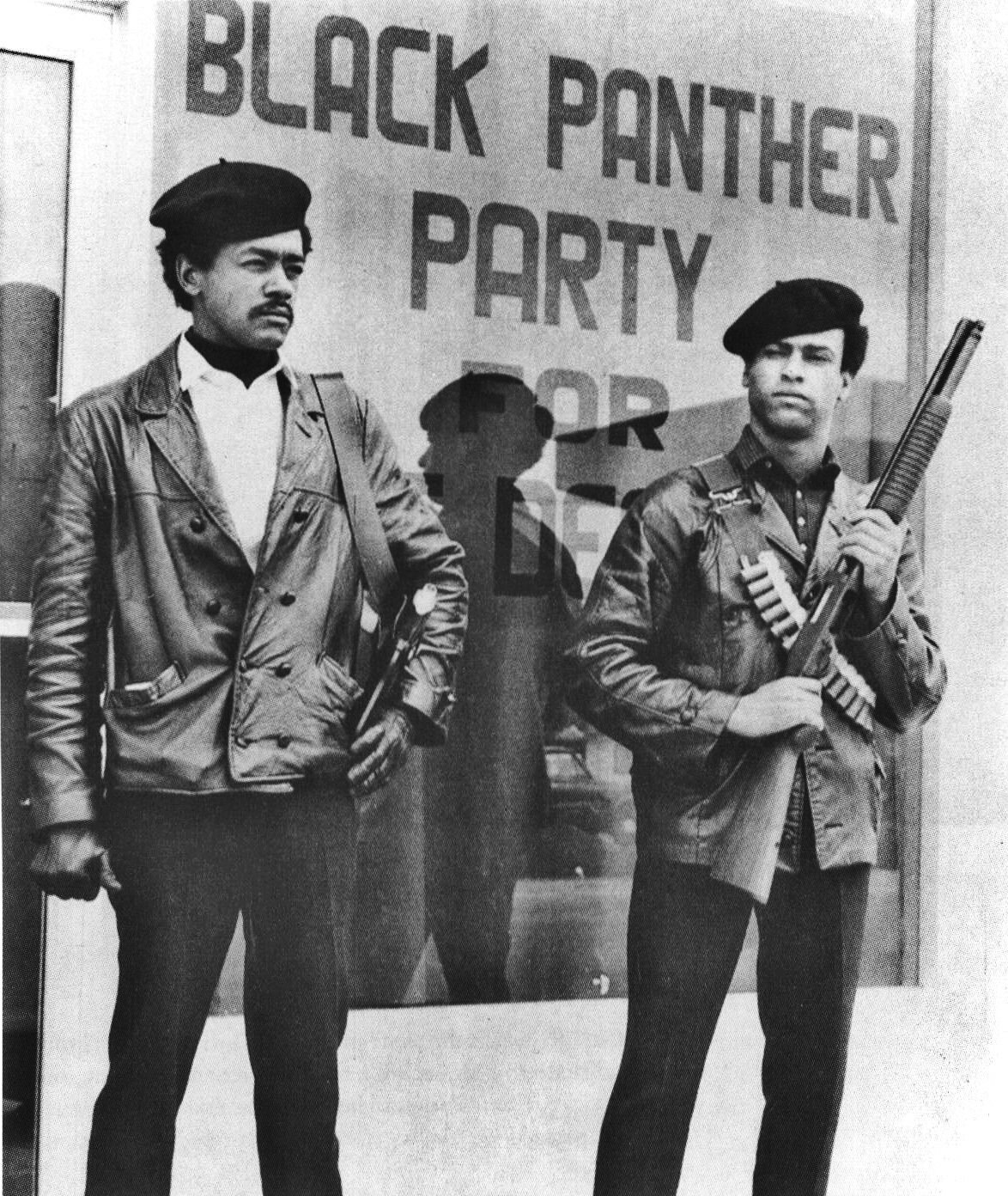 Bobby Seale (left) and Huey P. Newton (right) standing outside the Black Panther Party Oakland office. The window behind them reads 'BLACK PANTHER PARTY FOR SELF-DEFENSE.' Newton holds a shotgun. Both wear berets and leather jackets. From a BPP self-published poster, P.O. Box 8641, Emeryville, California.